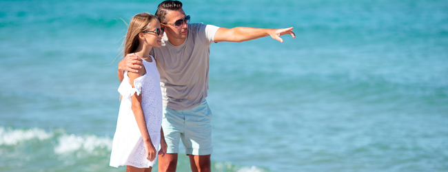 Vater zeigt seiner Tochter die Aussicht am Strand während eines Spaziergangs am Meer auf einer LISA! Familiensprachreise