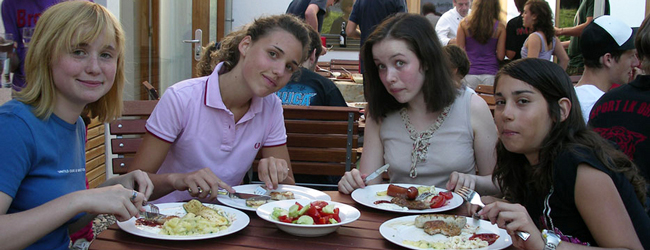 Vier Mädchen sitzen am Tisch und essen gemeinsam zu Mittag bei einer Sprachreise für Schüler