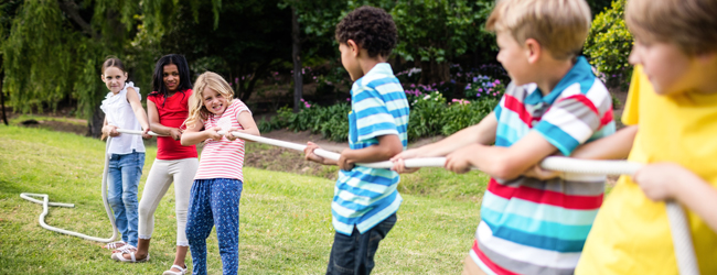 Drei Mädchen und drei Jungen ziehen an einem Seil im Garten der LISA! Sprachschule in Edinburgh