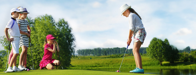 Vier Kinder spielen Golf auf einer grünen Wiese während einer Sprachreise für Schüler in Wells Cathedral