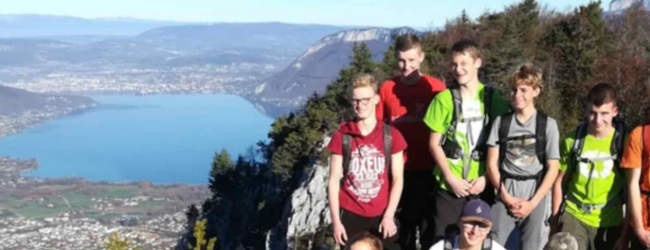 Blick auf den Bergsee in Annecy mit posierenden Jungen im Vordergrund